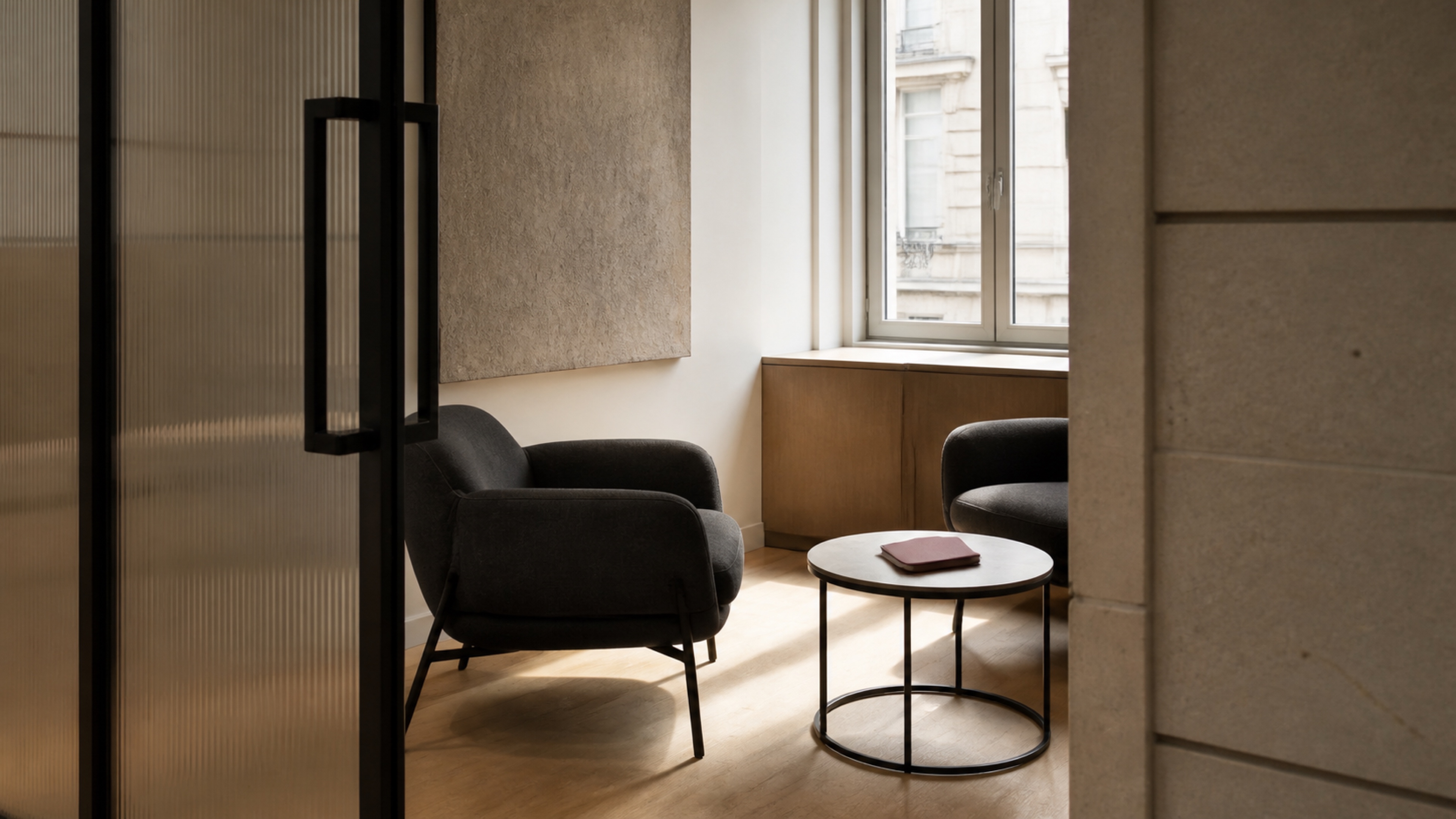An inviting two-chair meeting lounge with one burgundy notebook
